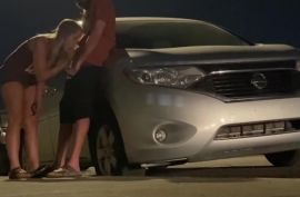 Возле машины красивая девушка сосет